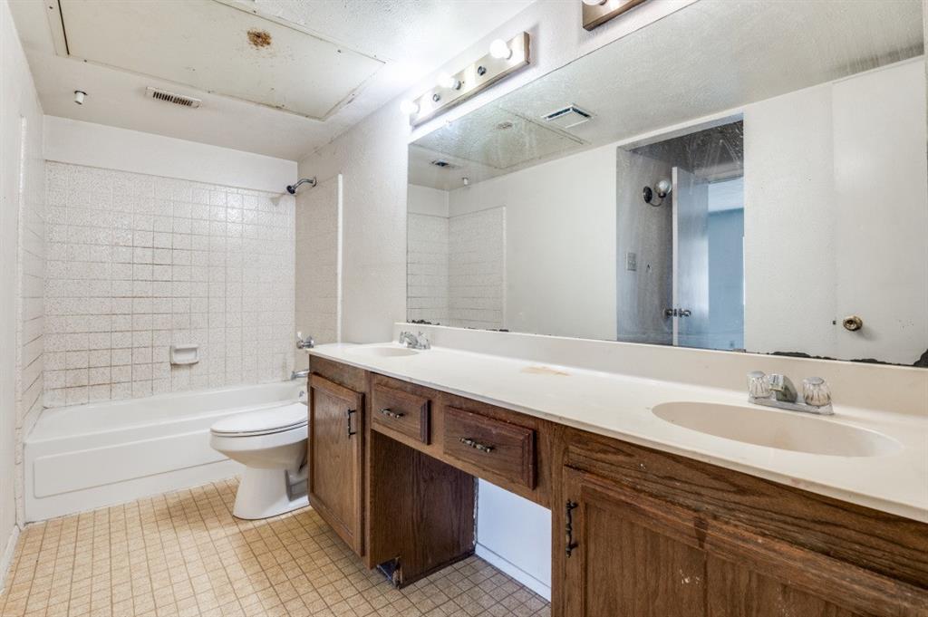 7049 Sorcey Road Dallas, TX 75249 - Photo 10 of 12 a bathroom with a double vanity sink toilet and shower