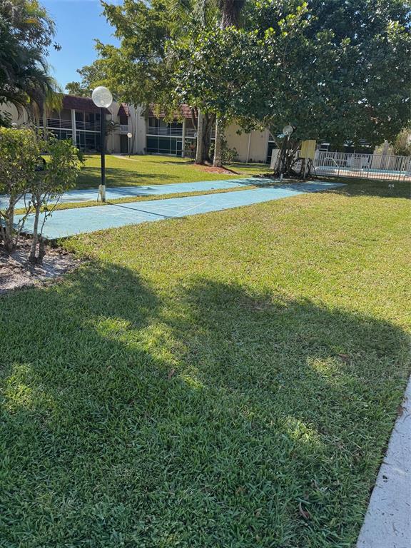 3774 Inverrary Boulevard, Unit 106P Lauderhill, FL 33319 - Photo 23 of 29 a view of a swimming pool with a big yard and large trees