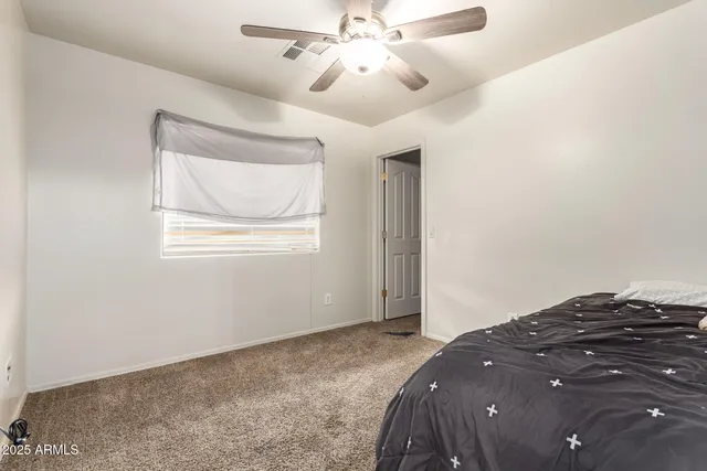 a bedroom with a bed and a chandelier fan