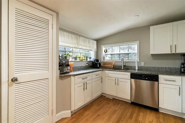 a kitchen with granite countertop white cabinets and white appliances