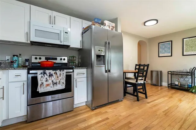 a kitchen with stainless steel appliances granite countertop a refrigerator and a stove top oven