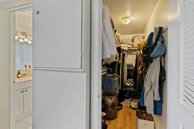a view of walk in closet with clothes and shoes