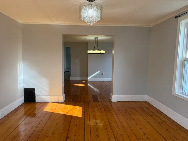 a view of a room with wooden floor staircase and a kitchen