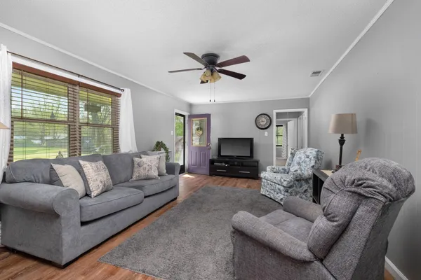 a living room with furniture fireplace and a large window