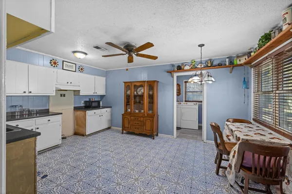 a kitchen with cabinets and wooden floor