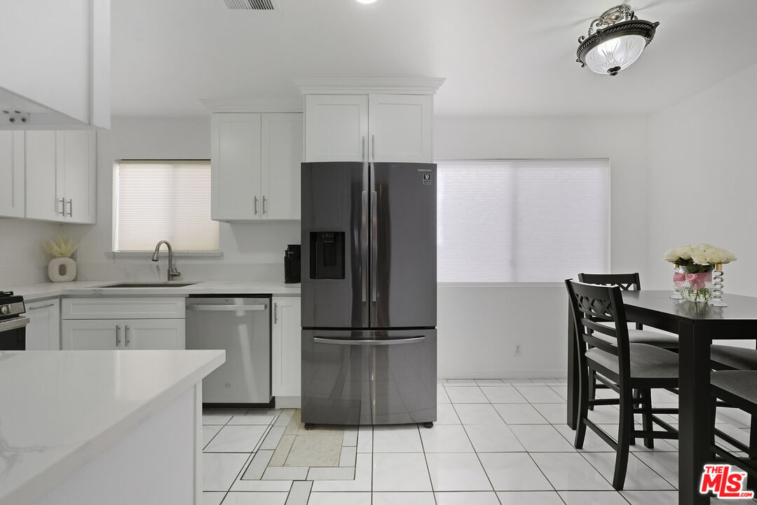 7422 Hazeltine Avenue, Unit 3 Van Nuys, CA 91405 - Photo 11 of 36 a kitchen with a refrigerator a table and chairs