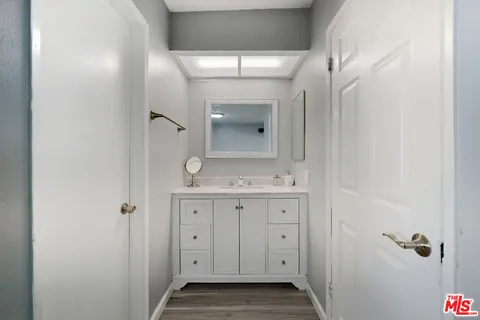 a bathroom with a granite countertop sink a toilet and a mirror