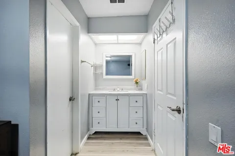 a bedroom with a bed large mirror on dresser and a window