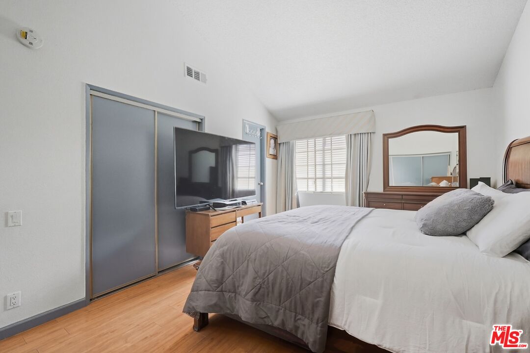 7422 Hazeltine Avenue, Unit 3 Van Nuys, CA 91405 - Photo 20 of 36 a bedroom with a bed large mirror on dresser and a window