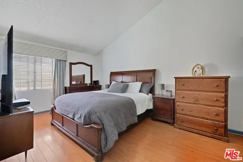 a bedroom with a bed and wooden floor