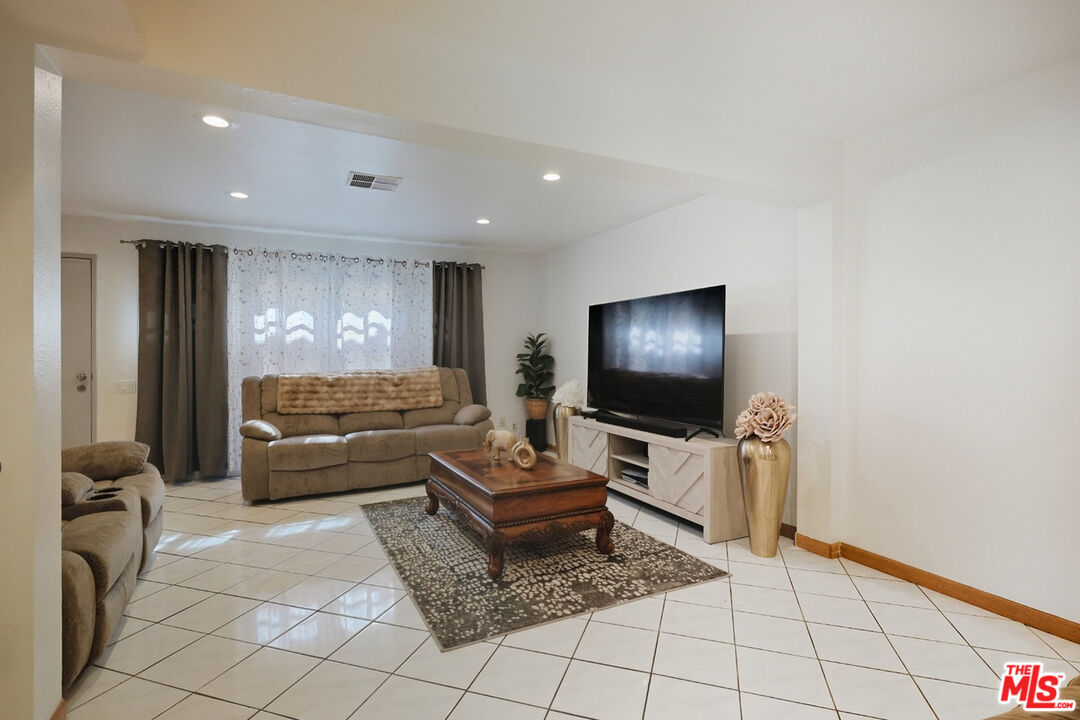 7422 Hazeltine Avenue, Unit 3 Van Nuys, CA 91405 - Photo 3 of 36 a living room with furniture and a flat screen tv