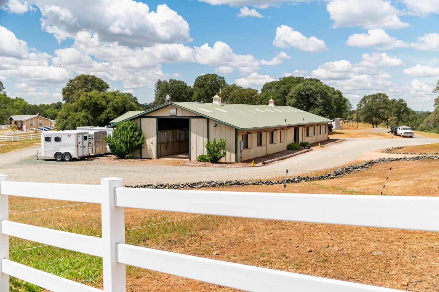 20945 Bear Hollow Road Grass Valley, CA 95949 - Photo 25 of 82 a white house with a big yard and large trees