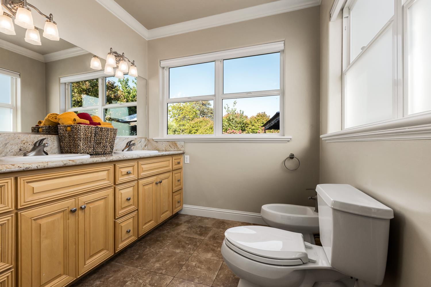 20945 Bear Hollow Road Grass Valley, CA 95949 - Photo 64 of 82 a bathroom with a granite countertop toilet a sink and a large mirror