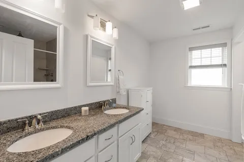 a bathroom with a granite countertop sink and a mirror