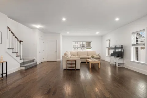 a living room with furniture and a wooden floor