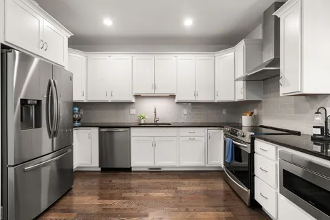 a kitchen with stainless steel appliances granite countertop a stove a refrigerator and a sink