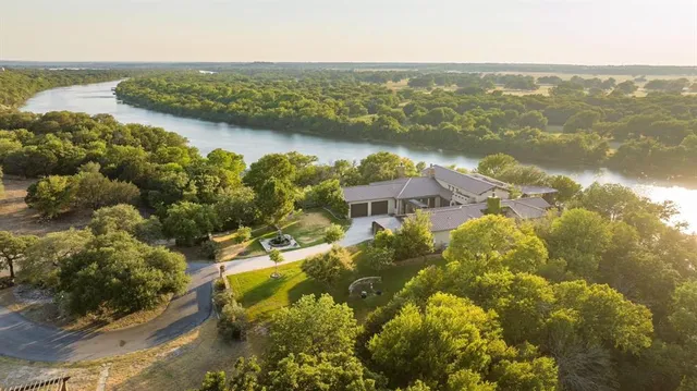 an aerial view of residential houses with outdoor space and river
