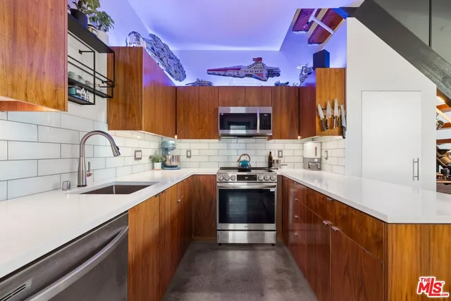 a kitchen with stainless steel appliances stove a sink and a microwave