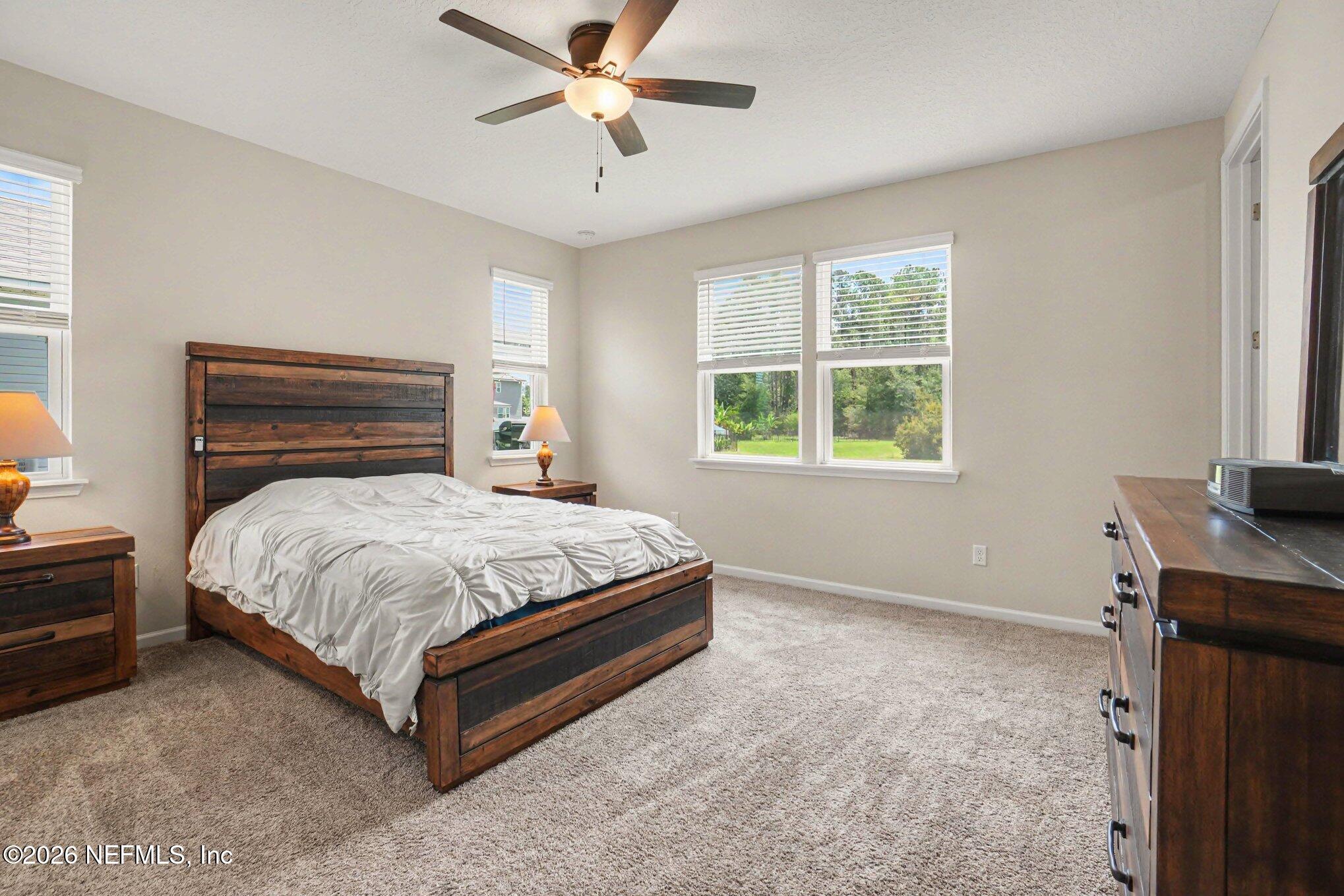 4630 Pine Ridge Parkway Middleburg, FL 32068 - Photo 13 of 35 a bed sitting in a bedroom next to a window