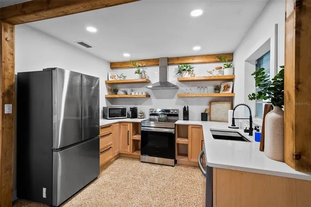a kitchen with stainless steel appliances granite countertop a refrigerator sink and stove