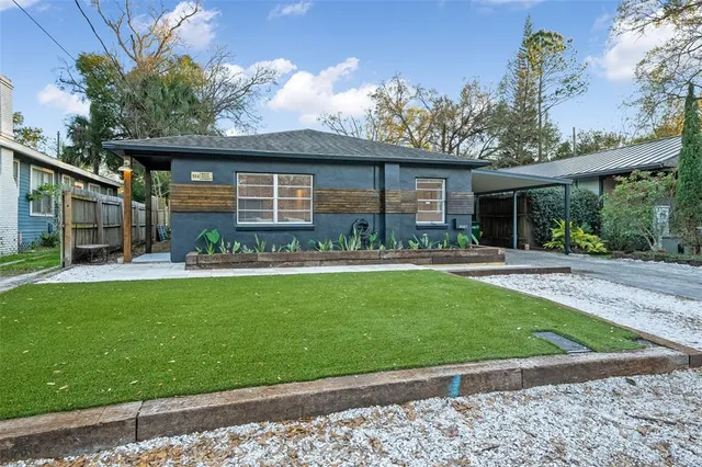 a front view of a house with a garden and plants