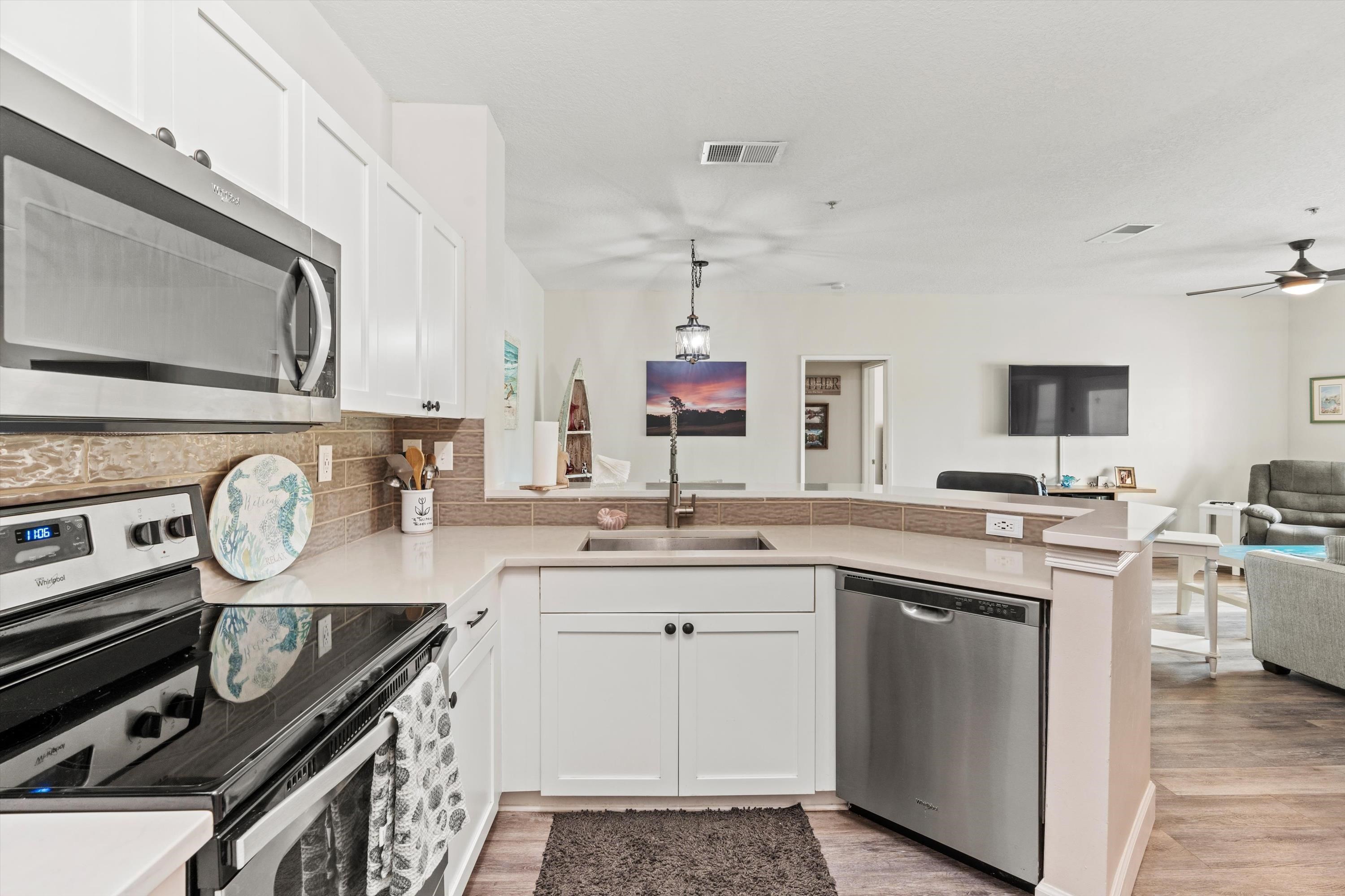 540 Florida Club Boulevard, Unit 210 St. Augustine, FL 32084 - Photo 32 of 33 Kitchen with stainless steel appliances, open floor plan, white cabinetry, a peninsula, and pendant lighting