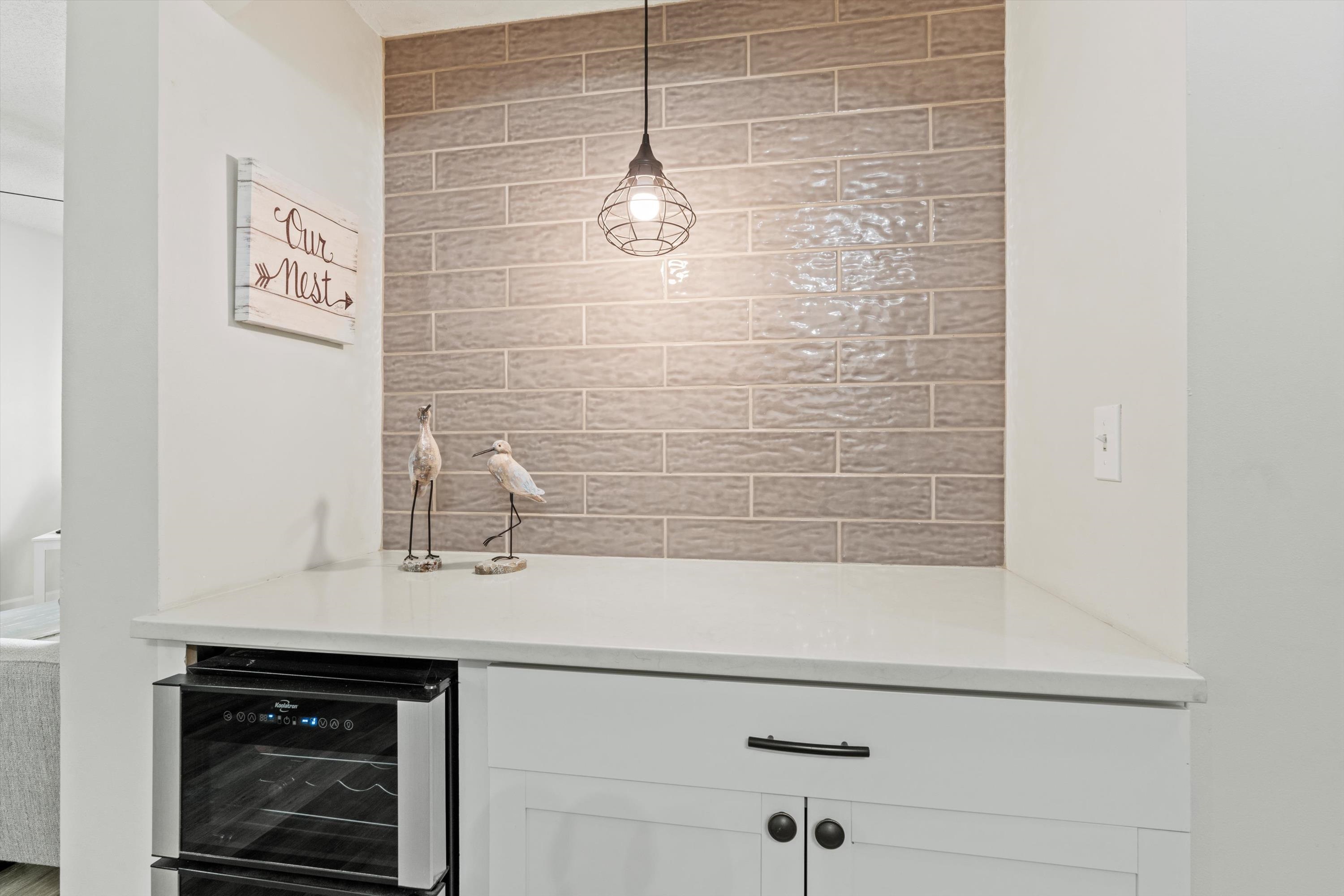 540 Florida Club Boulevard, Unit 210 St. Augustine, FL 32084 - Photo 8 of 33 Bar area with white cabinetry, wine cooler, pendant lighting, and light stone countertops