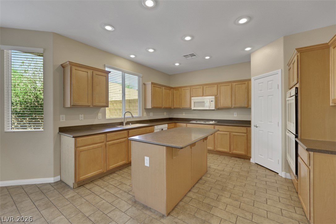 10328 Hawk Ravine Street Las Vegas, NV 89178 - Photo 13 of 55 A well-appointed kitchen features ample cabinetry, an island, and a generous amount of countertop space.