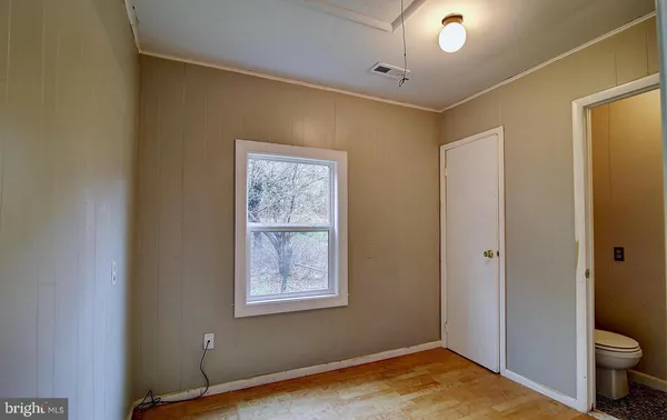a view of empty room with wooden floor
