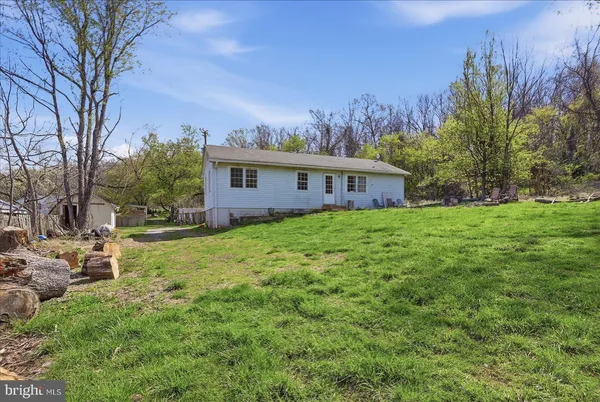 a view of house with backyard and trees