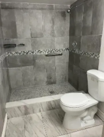 a white toilet next to a bathroom