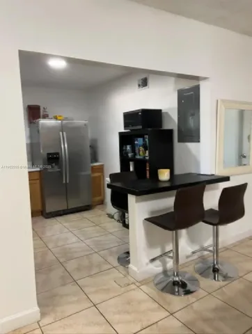 a kitchen with granite countertop a refrigerator cabinets and stove top oven