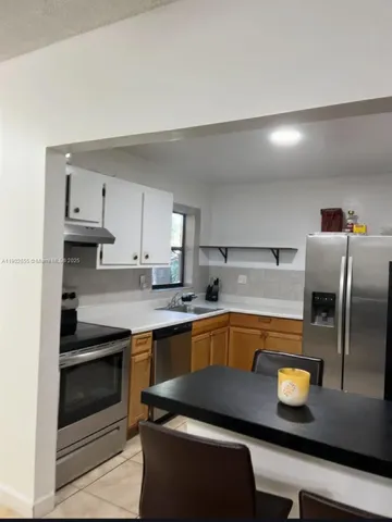 a kitchen with stainless steel appliances granite countertop a sink and a stove