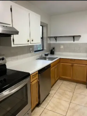a kitchen with a sink and a stove top oven