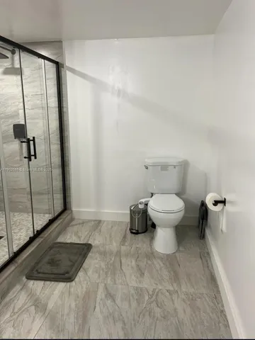 a bathroom with a toilet and a shower
