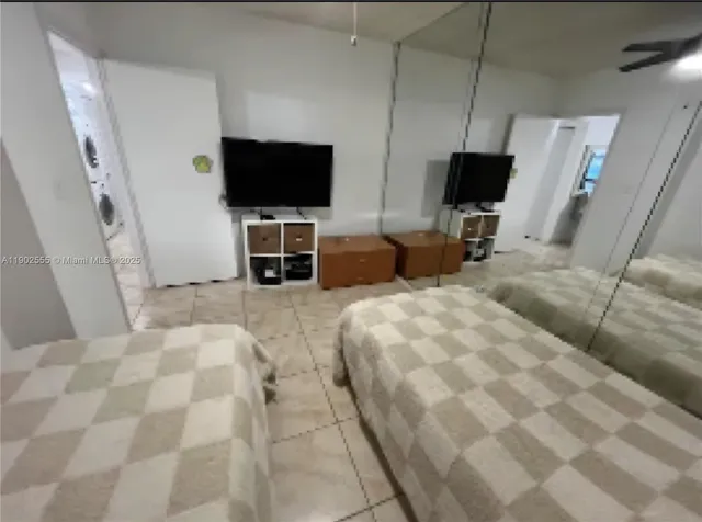 a bedroom with a bed tv and chair