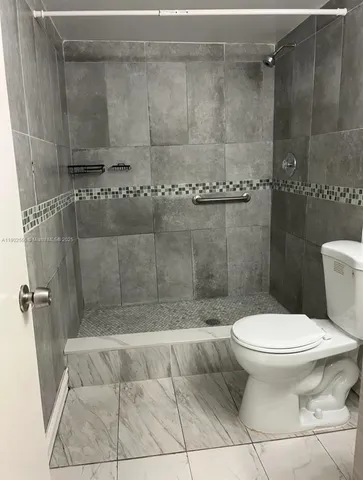 a bathroom with a toilet and a shower