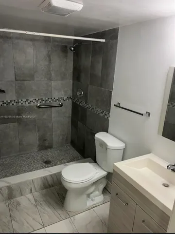 a white toilet sitting next to a bathroom sink