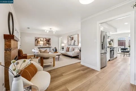 a living room with furniture wooden floor and a large window