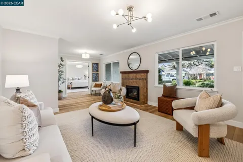 a living room with furniture a fireplace and a table