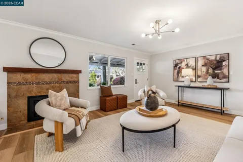 a living room with furniture a rug and wall paintings