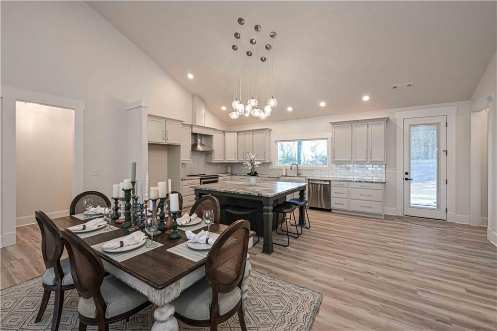 3667 Jones Mill Road Carrollton, GA 30116 - Photo 13 of 66 a dining room with kitchen island a dining table wooden floor and a view of kitchen