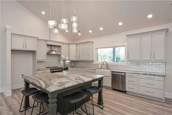a kitchen with kitchen island granite countertop lots of counter top space and stainless steel appliances
