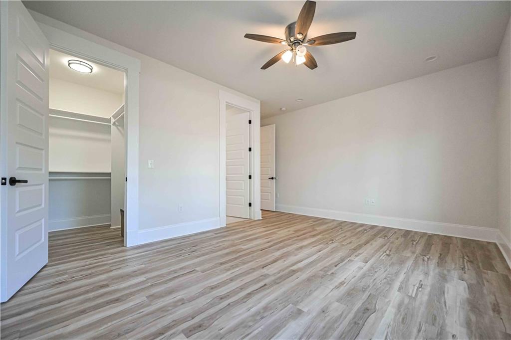 3667 Jones Mill Road Carrollton, GA 30116 - Photo 28 of 66 an empty room with wooden floor and ceiling fan