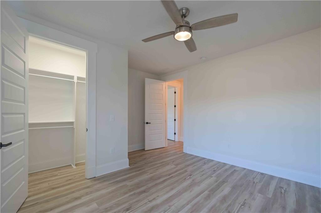 3667 Jones Mill Road Carrollton, GA 30116 - Photo 34 of 66 an empty room with wooden floor fan and windows