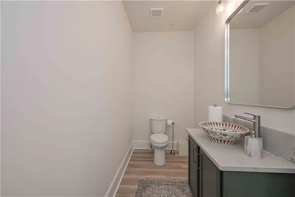 a kitchen with a refrigerator and wooden floor