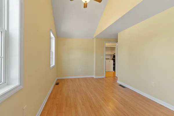 a view of a big room with wooden floor and a window
