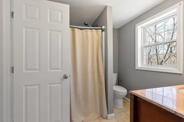 a bathroom with a sink a toilet and a window