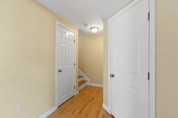 a view of a hallway with wooden floor and staircase