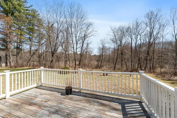 a view of a roof deck with wooden fence and trees